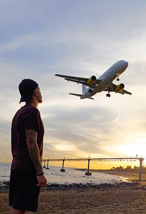 Una fotografía de un chico mirando un avión aterrizando