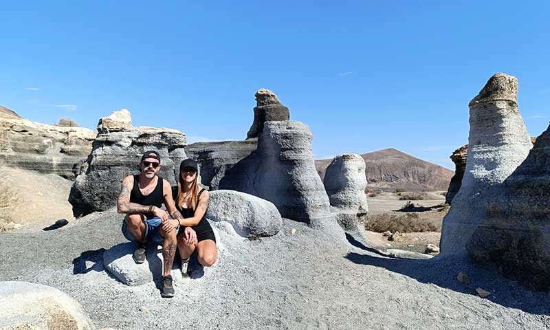 Una fotografía de una pareja en un paisaje de piedra y arena