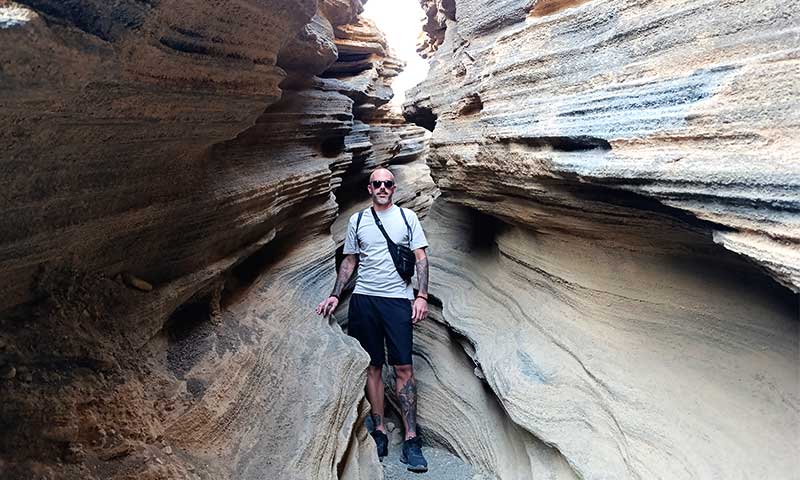 Una fotografía de un chico entre unas gritas de piedra