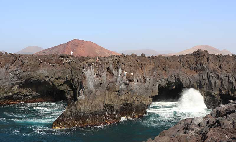 Una fotografía del mar rompiendo contra las rocas