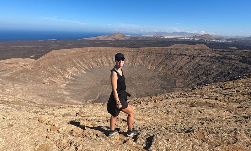 Una chica en la ladera de un volcán