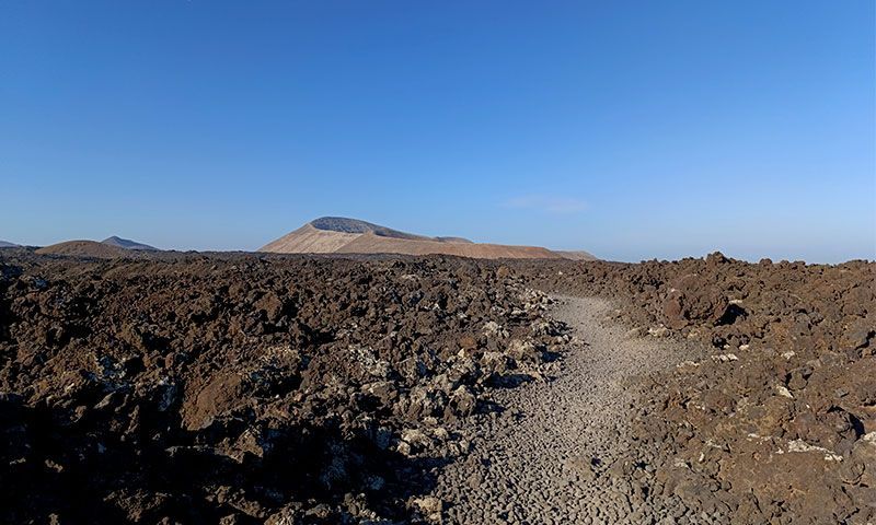 Un camino de senderismo entre roca volcánica