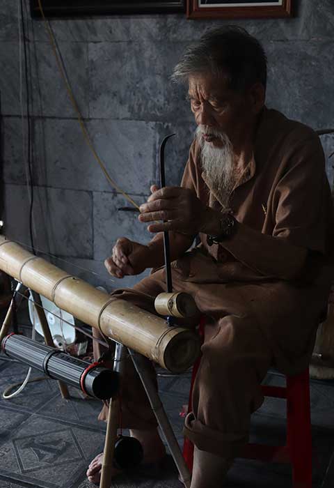 Monje tocando un instrumento en Tam Coc