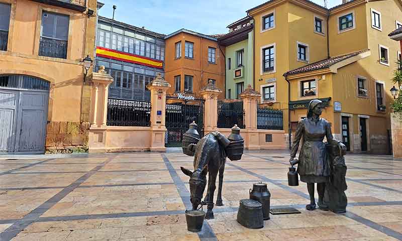Plaza de Trascorrales con una estatua de un burro y una señora.