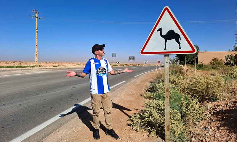 Señal de tráfico con coche de alquiler en Marruecos