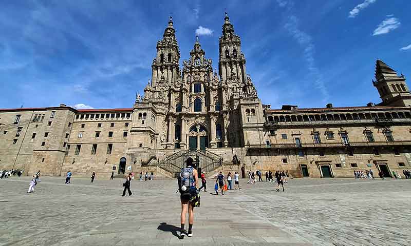 Chica con mochila delante de la Catedral de Santiago