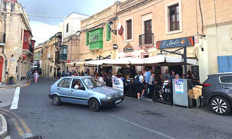 Coche circulando por una calle de Malta en un entorno urbano