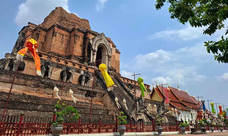 Gran chedi de ladrillo antiguo de Wat Chedi Luang decorado con farolillos coloridos en Chiang Mai.